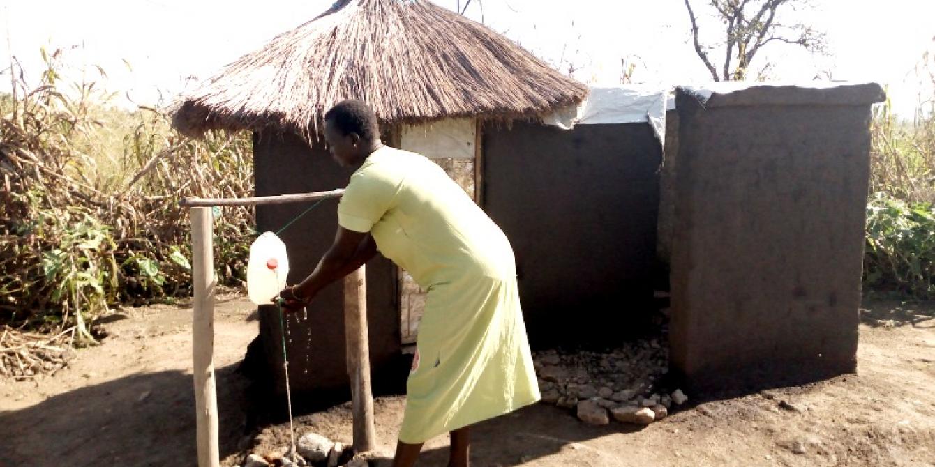 Betty 31 years and single mother of 6 children demonstrates hand-washing at her home latrine Photo: Robert Ariaka/Oxfam Betty 31 years and single mother of 6 children demonstrates hand-washing at her home latrine Photo: Robert Ariaka/Oxfam